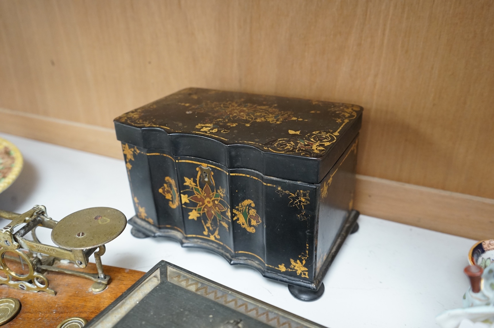 A Victorian papier maché tea caddy, postal scales and a military interest cigarette box, largest 19cm wide